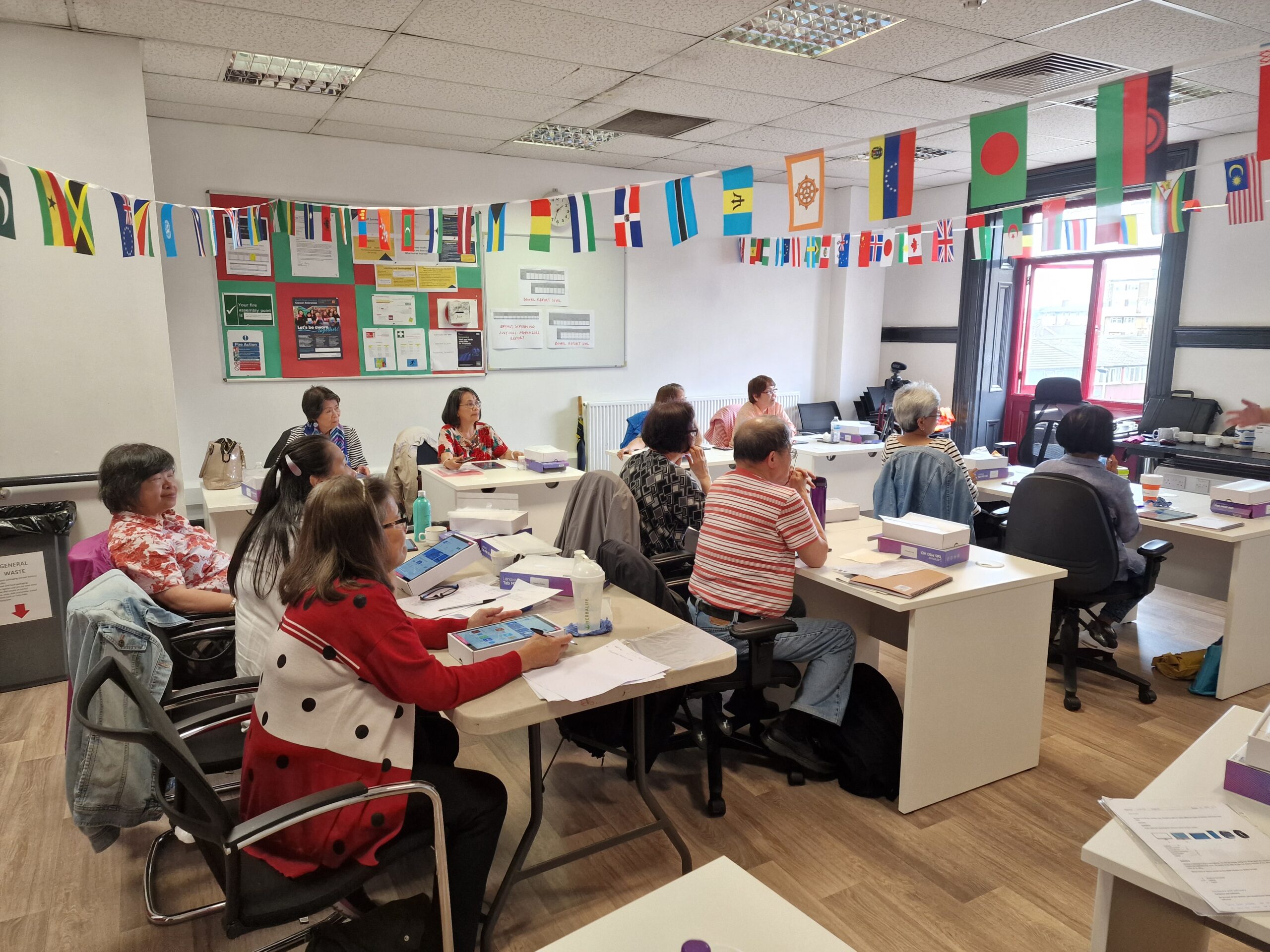 A group of older adults learning digital skills with Community Clicks in the classroom