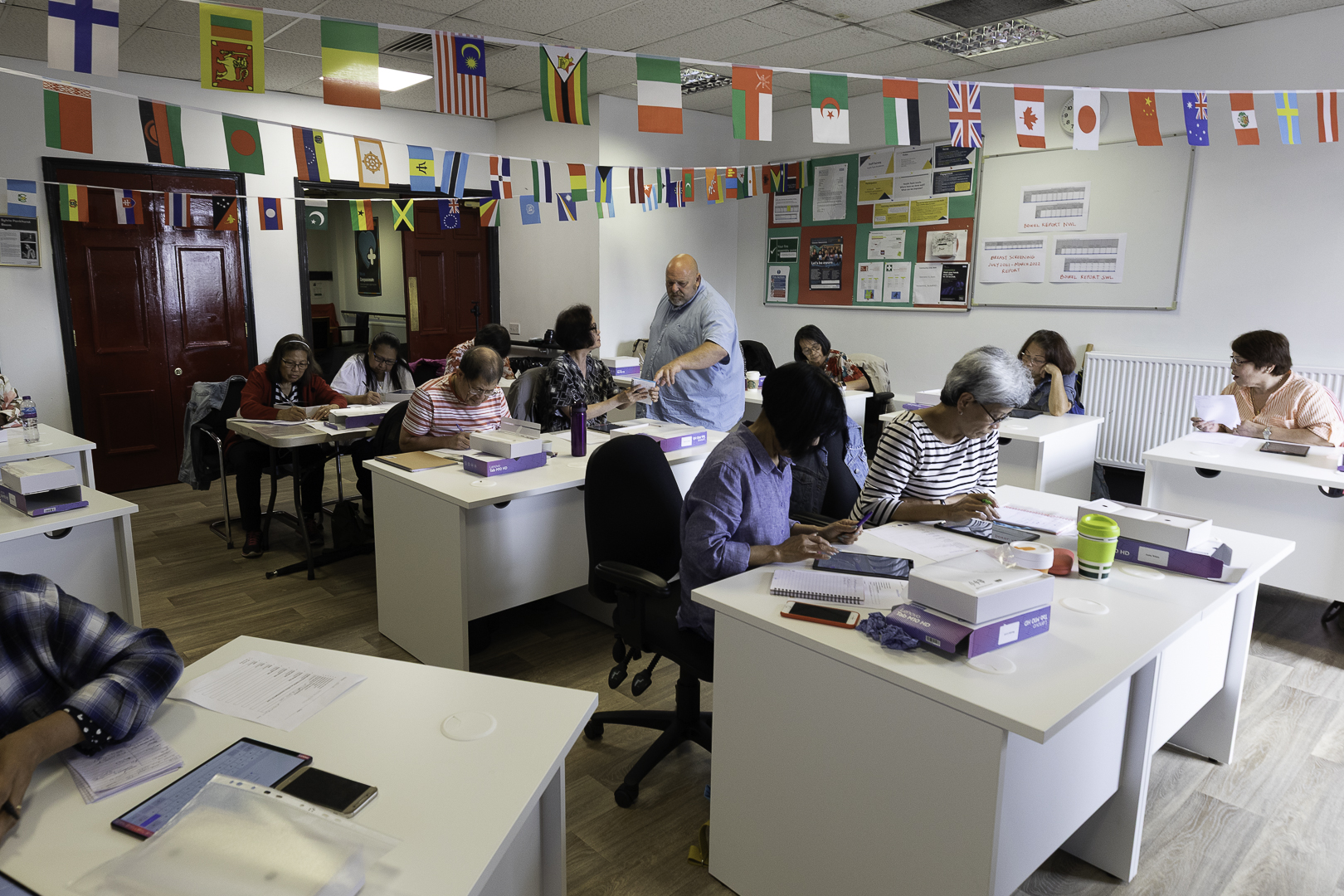 A classroom of older adults learners and teacher learning on a digital skills programme.