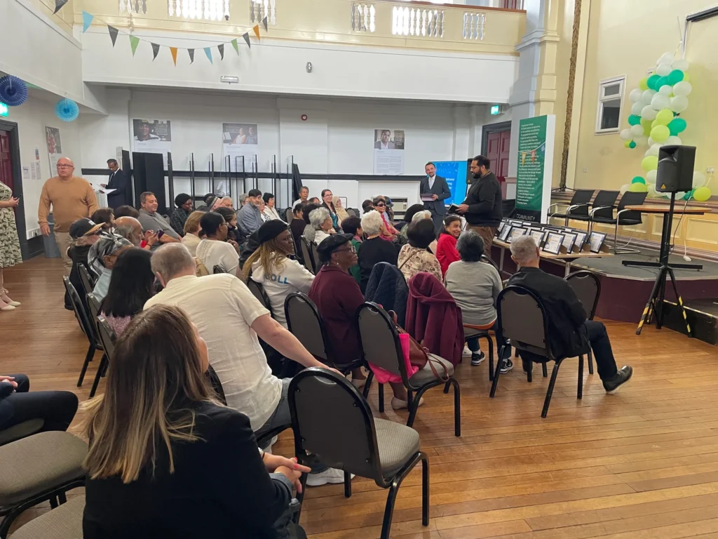 Older learners sat on chairs at a graduation ceremony